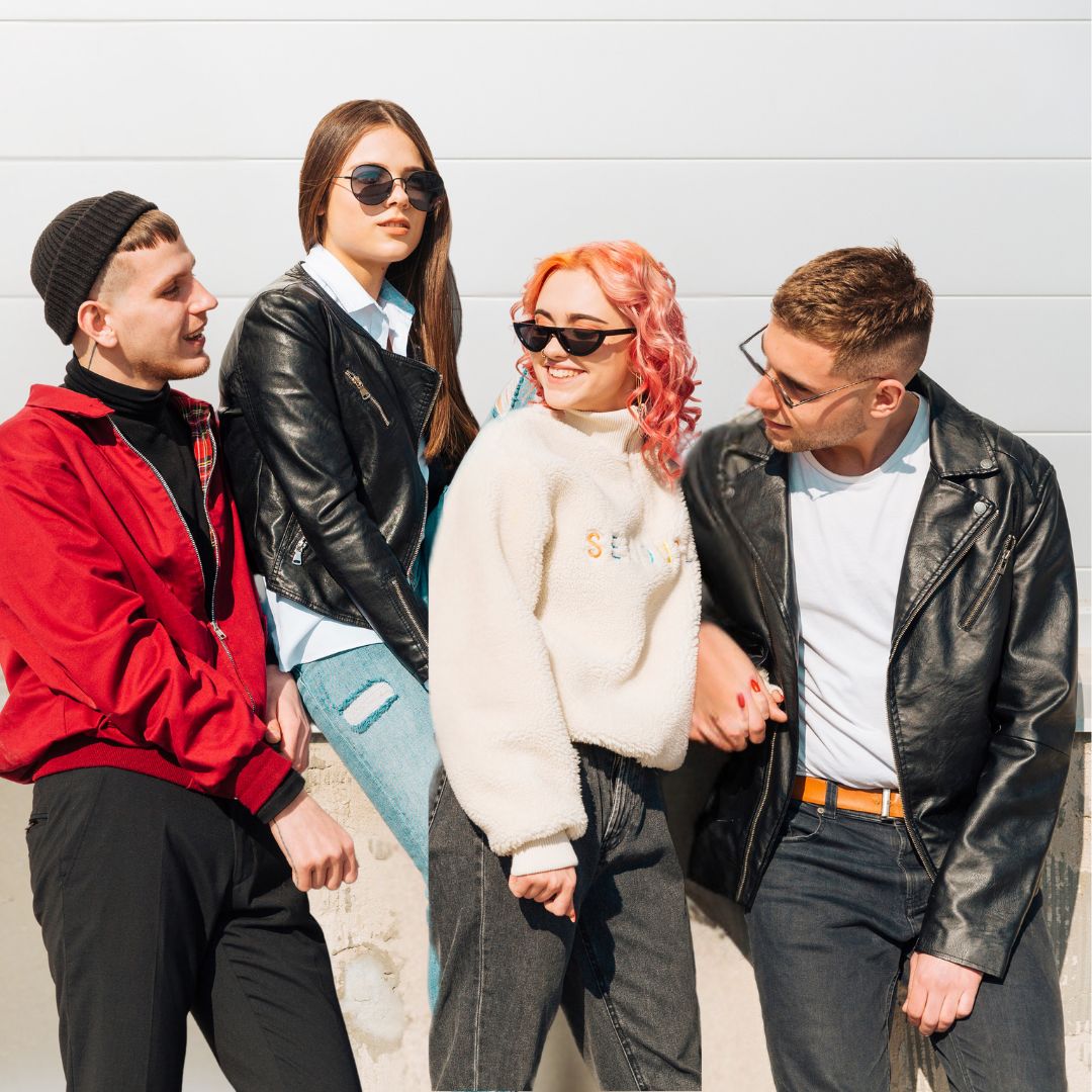 Four young people in leather jackets and jeans, representing a modern take on leather clothing trends in the UK
